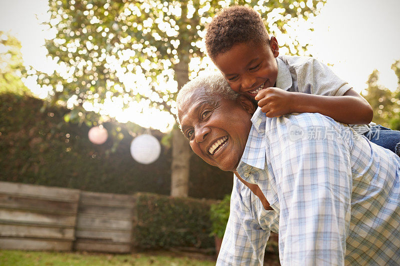 年轻的黑人男孩爬上他的grandfatherâ在花园里